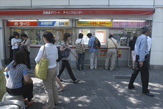 JAPAN, Honshu, Tokyo, Ginza. People buying tickets at a kiosk for a popular high stakes lottery