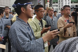 JAPAN, Chiba, Narita, Gion Matsuri with men in  traditional Edo-era costumes toasting each other