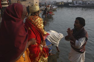 INDIA, Uttar Pradesh, Varanasi , Bhramin pundit or priest stands in the Ganges River at