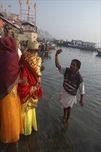 INDIA, Uttar Pradesh, Varanasi , Bhramin pundit or priest at Dashaswamedh Ghat stands in the Ganges