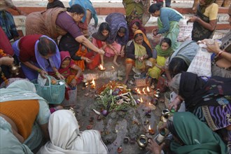 INDIA, Uttar Pradesh, Varanasi , Hindu women worship an earthen statue of Hindu God Bhim at Asi