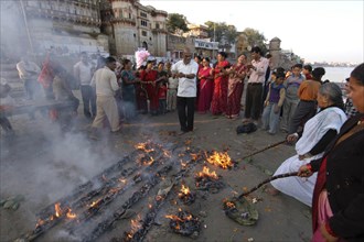 INDIA, Uttar Pradesh, Varanasi , Nepali man dances at a Hindu ceremony at Asi Ghat beside the