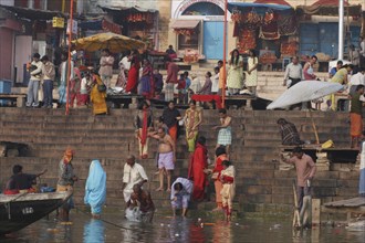 INDIA, Uttar Pradesh, Varanasi, Dashaswamedh Ghat with early morning bathers in the Ganges River