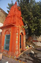 INDIA, Uttar Pradesh, Varanasi, Near Chuki Ghat. A Shiva Shrine painted orange
