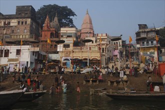 INDIA, Uttar Pradesh, Varanasi, Dashaswamedh Ghat with early morning pilgrims bathing in the Ganges