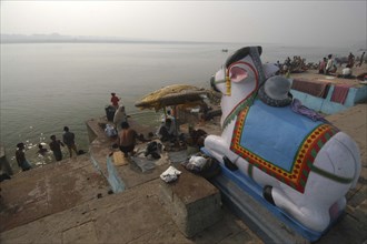 INDIA, Uttar Pradesh, Varanasi, Figure of Shivas bull Nandi overlooking the steps of Ghai Ghat by