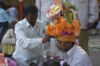 INDIA, Uttar Pradesh, Varanasi, Sankat Mochan Mandir temple. A groom having his headdress / hat