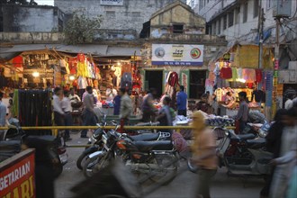 INDIA, Uttar Pradesh, Varanasi, Godaulia Area. Evening shopping scene with streetside shops