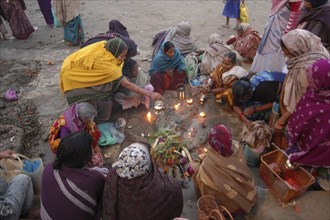 INDIA, Uttar Pradesh, Varanasi, Hindu women worshipping an earthen image of Hindu God Bhim at Asi