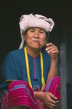 THAILAND, Chiang Mai, Doi Inthanon National Park. Portrait of a Karen woman sitting on the steps of