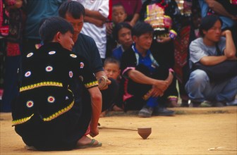 THAILAND, Chiang Mai, Hmong men spinning top at Hmong New Year festival