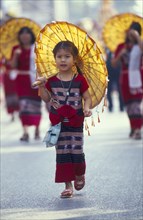 THAILAND, Chiang Mai, Young girl in Flower festival parade dressed in traditional attire with a