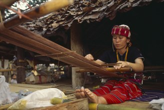 THAILAND, Chiang Mai, Sgaw Karen woman weaving cloth on a back strap loom