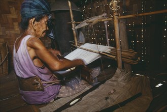 MYANMAR, Kachin State, Myitkyina, 116 year old Jinghpaw woman weaving on a back strap loom