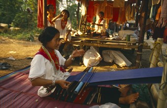 THAILAND, Chiang Mai, Young Lawa woman weaving on a back strap loom