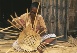 THAILAND, Chiang Mai Province, Red Lahu man weaving a bamboo basket