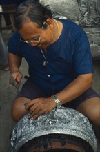 THAILAND, Chiang Mai, Silversmith making large silver bowl