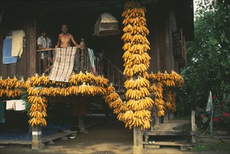 THAILAND, Chiang Mai Province, Muen Keurt, Bunches of shucked corn drying on the porch of a rural