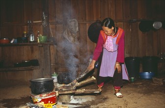 THAILAND, Chiang Mai Province, Chiang Dao District, Young Lisu woman working in her kitchen in Bahn