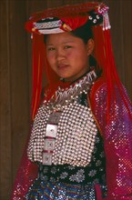 THAILAND, Chiang Rai Province, Doi Lan, Young Lisu woman in her New Year finery prior to going to a
