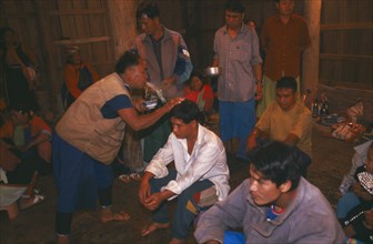 THAILAND, Chiang Rai Province, Doi Lan, Lisu shaman spraying supplicants head at healing ceremony