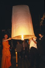 THAILAND, Chiang Mai, Wat Chaimongkon, Loi Krathong Festival aka Yi Peng. Monk and other people