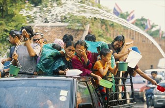 THAILAND, Chiang Mai, Songkran aka Thai New Year. Revellers in a pickup truck attempting to catch