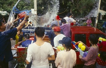 THAILAND, Chiang Mai, Songkran aka Thai New Year. Revellers in a pickup truck attempting to catch