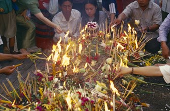 THAILAND, Chiang Mai, Wat Jedi Luang, Inthakhin Ceremony. People with offerings of flowers candles