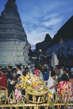 THAILAND, Chiang Mai, Wat Jedi Luang, Inthakhin Ceremony. People with offerings of flowers and joss