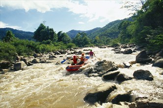 THAILAND, Chiang Mai Province, Western tourists and Thai guides white water river rafting on the