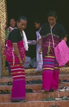 THAILAND, Chiang Mai, Wat Phra Singh, Two Karen women finding their shoes on steps upon leaving a
