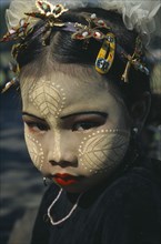 MYANMAR, Lake Taungthaman , Portrait of young girl with face decorated with leaf patterns  and