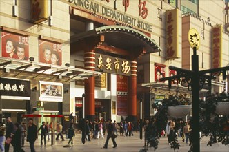 CHINA, Beijing, Wanfujing Dajie department store.  Entrance on to busy street with advertising