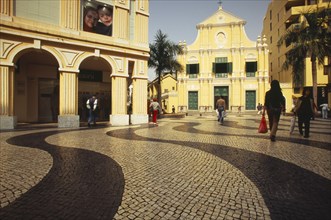 CHINA, Macau, Church of St Dominic.  Exterior with people walking across mosaic tiled area in the
