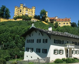 GERMANY, Bayern, Hohenschwangau, Hohenschwangau Castle on hillside overlooking white painted