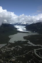 USA, Alaska, Juneau, Aerial view over town and waters leading toward snow covered valley and