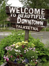 USA, Alaska, Talkeetna, Wooden welcome sign standing in flower tub