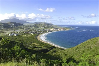 WEST INDIES, St Kitts, View over green hills and coastline with sandy bay