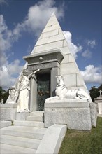 USA, Louisiana, New Orleans, Graveyard pyramid shaped vault with statue of sphinx and man outside