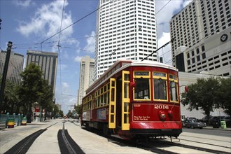 USA, Louisiana, New Orleans, Street Car travelling along tracks passing highrise buildings