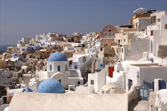 GREECE, Cyclades, Santorini, View over the towns predominantly white architecture with blue domed