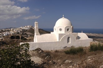 GREECE, Cyclades, Santorini, Whitewashed Church with domed roof overlooking the town