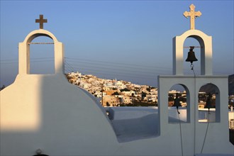 GREECE, Cyclades, Santorini, Bell tower of whitewashed church overlooking the town