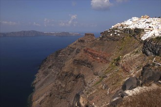 GREECE, Cyclades, Santorini, View along rugged coastal cliffs with the white architecture of the