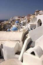 GREECE, Cyclades, Santorini, View over white town architecture with occasional blue domes