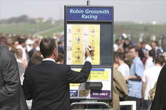 ENGLAND, East Sussex, Brighton, Betting stall at Brighton Race Course with man writing in the odds