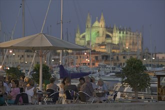 SPAIN, Balearic Islands, Majorca , Waterfront cafe at dusk in Palma de Mallorca with La Seo