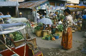 INDONESIA, Toraja, Market with sellers sitting around baskets of green vegetables with a market