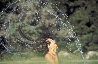 PEOPLE, Women, Woman in a swimming pool flings her wet hair over her head